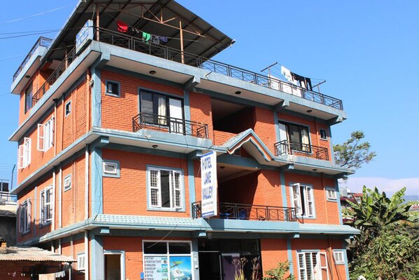 Un hotel de varios pisos con balcones y un letrero que indica que es un hotel.