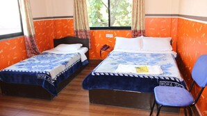 A room with two beds, a chair, and a window with curtains. - Hotel Lake Valley (Pokhara)