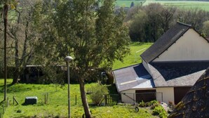 A rural landscape with a house featuring a sloped roof, a fenced yard, and a clear view of the surrounding countryside. - Valfrescos (Caurel)