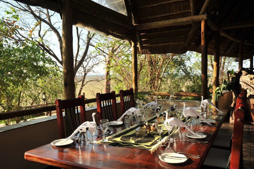 Mesa lista para una comida, con vista a árboles y un paisaje natural.