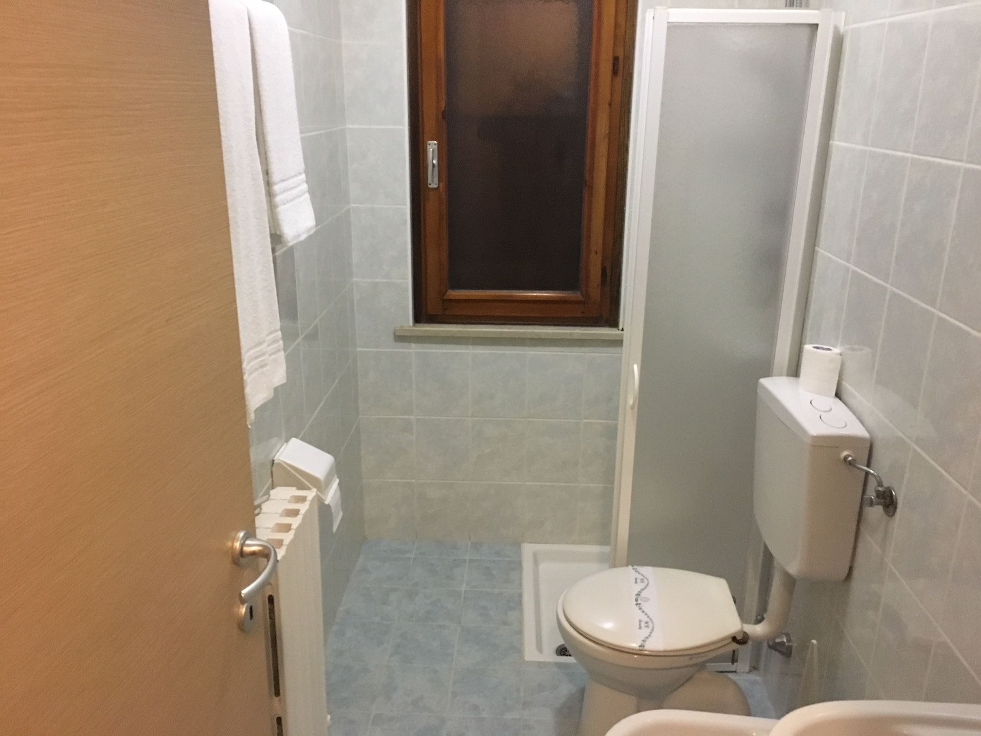 Ein kleines Badezimmer mit Toilette, Dusche und Waschbecken.