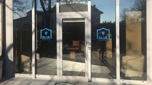 En hotelindgang med glasdøre og et synligt receptionsområde indeni.