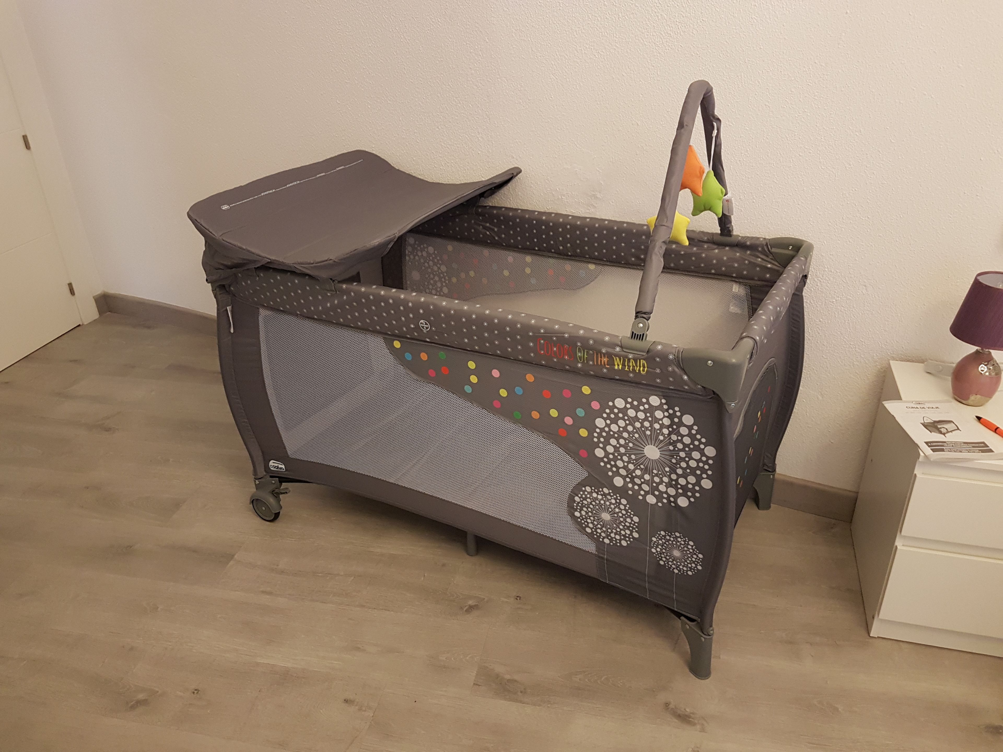 A baby stroller with a mesh seat and a canopy, featuring colorful dots and a dandelion pattern.