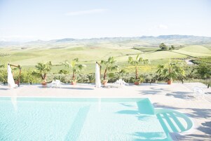 Una piscina al aire libre de temporada, una piscina infinita, sombrillas