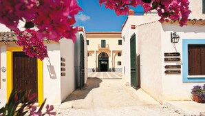 Une rue étroite bordée d’un immeuble où l’on peut voir des enseignes indiquant la présence d’une réception, d’une boutique de vins et d’un restaurant.