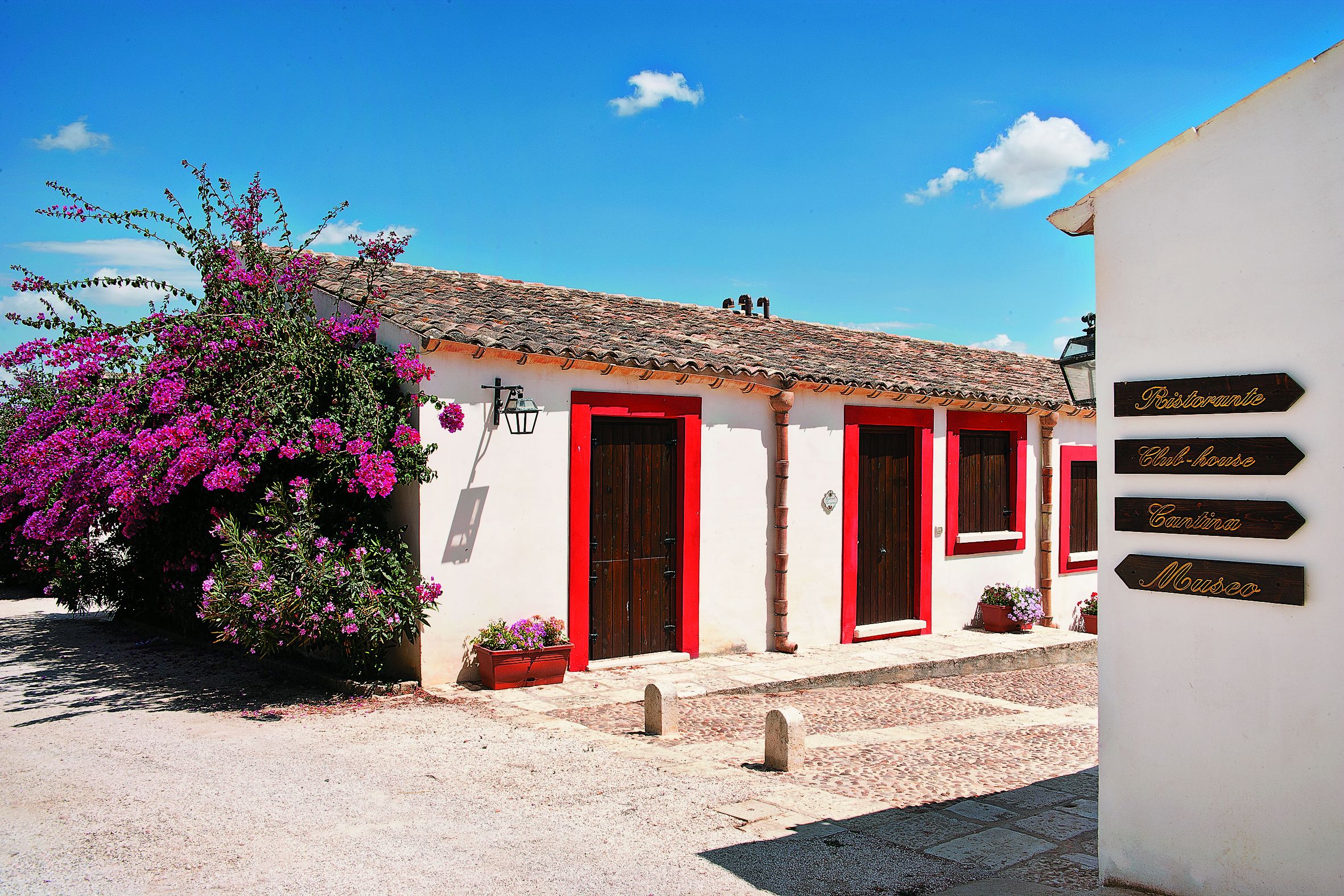 A building with red doors and a sign indicating a restaurant, club house, and museum.