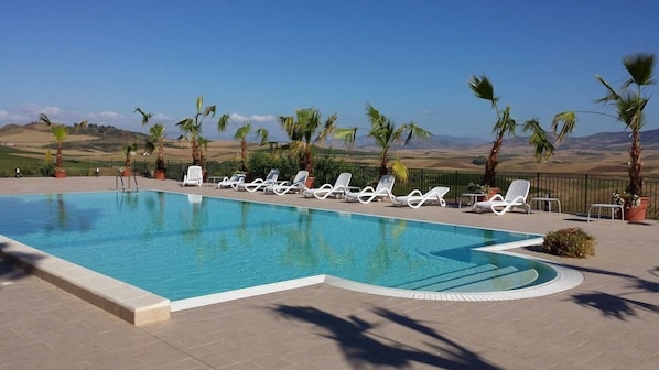 Seasonal outdoor pool, an infinity pool, pool umbrellas, pool loungers