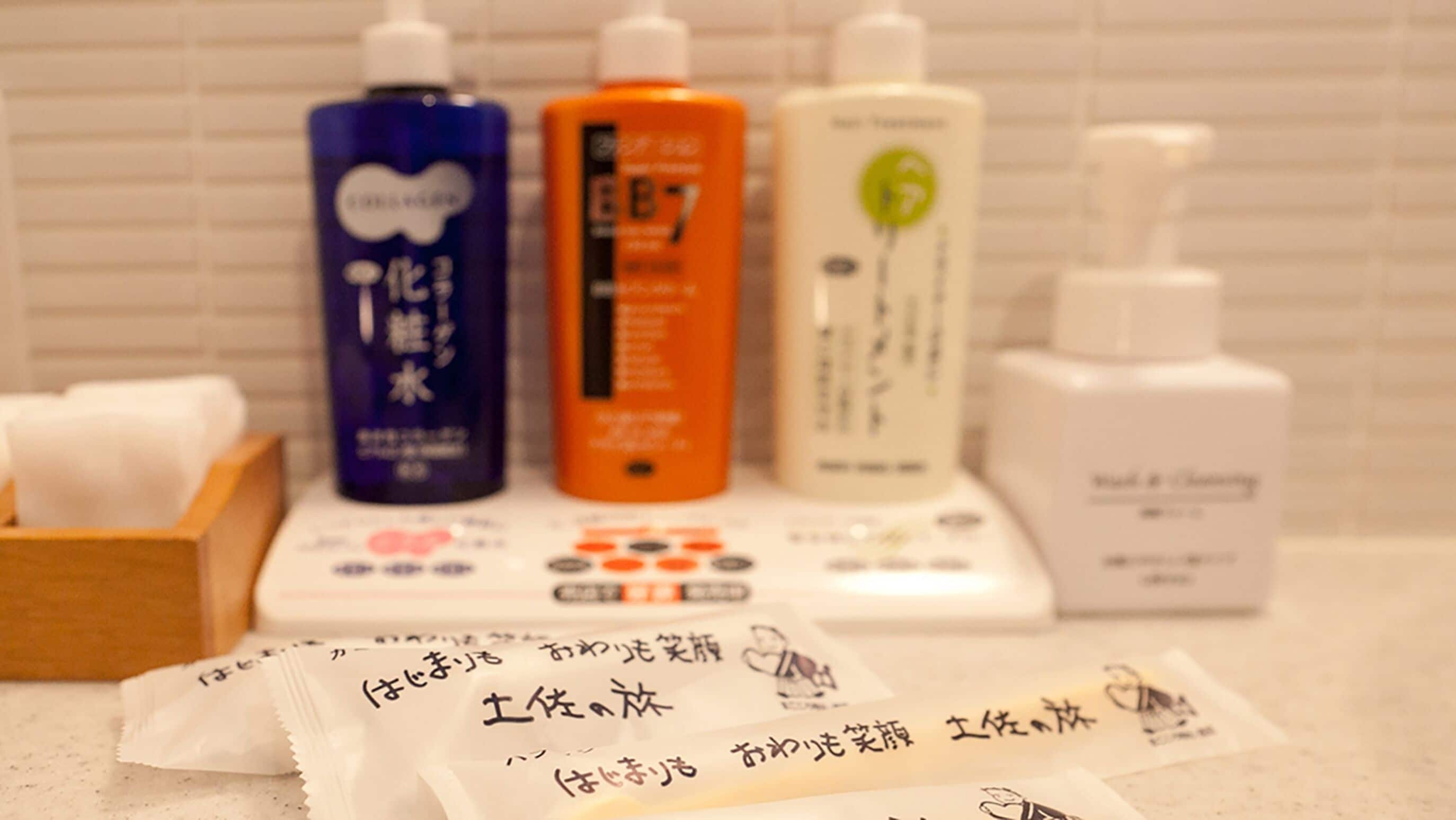 Ein Badezimmer-Waschtisch mit verschiedenen Pflegeprodukten, darunter Shampoo-, Conditioner- und Duschgel-Flaschen.