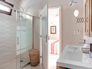 A modern bathroom with a glass shower enclosure, a white sink, and a wicker basket. - La Joya del Valle de Ricote (Villanueva Del Rio Segura)