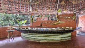 Un espacio interior con una mesa central de exhibición, redes colgantes y un mural que representa a un pescador.