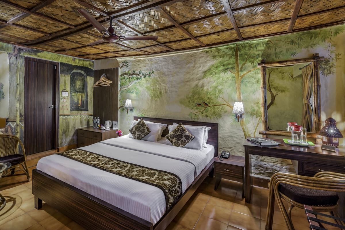 Ein Zimmer mit einem Bett, einem Schreibtisch, einem Stuhl, einem Tisch und einem Deckenventilator.