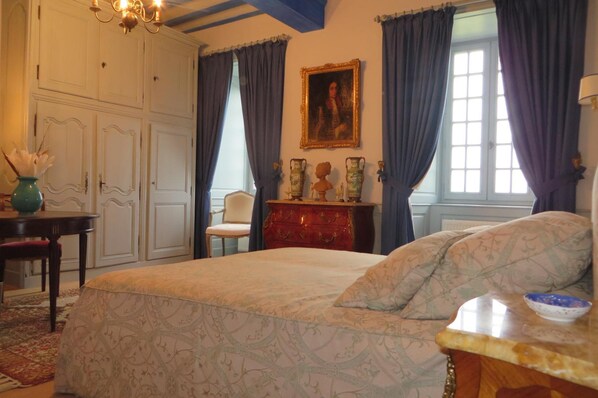 A bedroom with a bed, a dresser, a chair, and a painting on the wall. - Chateau de la Semondiere (Brecey)