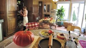 A kitchen with a large pumpkin, a rolling pin, and various kitchen utensils on the counter. - Les Insolites du Grand Logis (Marchais)