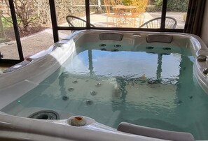 Uma banheira de hidromassagem com vista para móveis de exterior e um espaço de varanda.