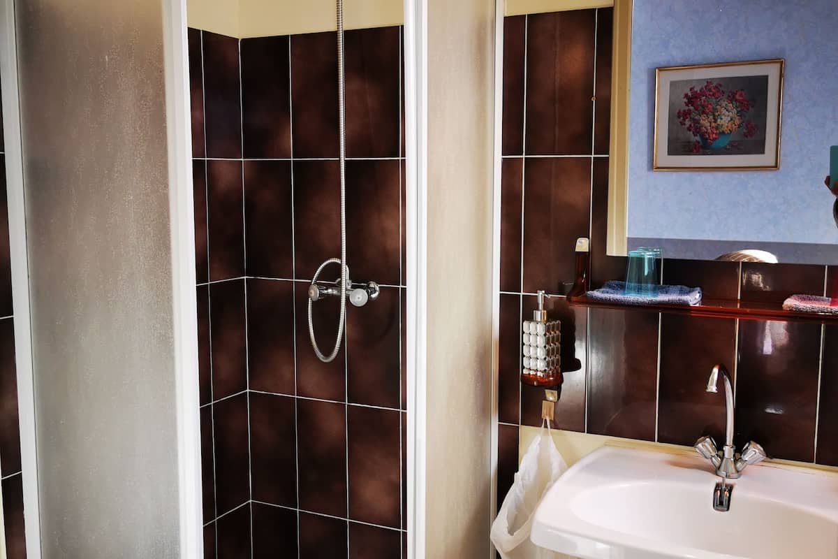 Ein Badezimmer mit Dusche, Waschbecken und Fliesen.