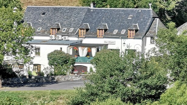 A traditional building with a sloped roof, multiple windows, and a sign indicating a bar. - Hôtel bar b’rock (Saint-Martin-sous-Vigouroux)