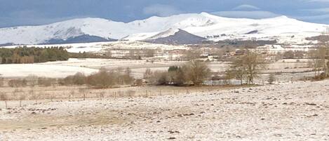 A snowy landscape with mountains in the background.
