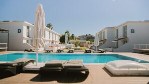 A swimming pool with lounge chairs and umbrellas, surrounded by buildings labeled 'D' and 'B'. - Vela Garden Resort (Cesme)