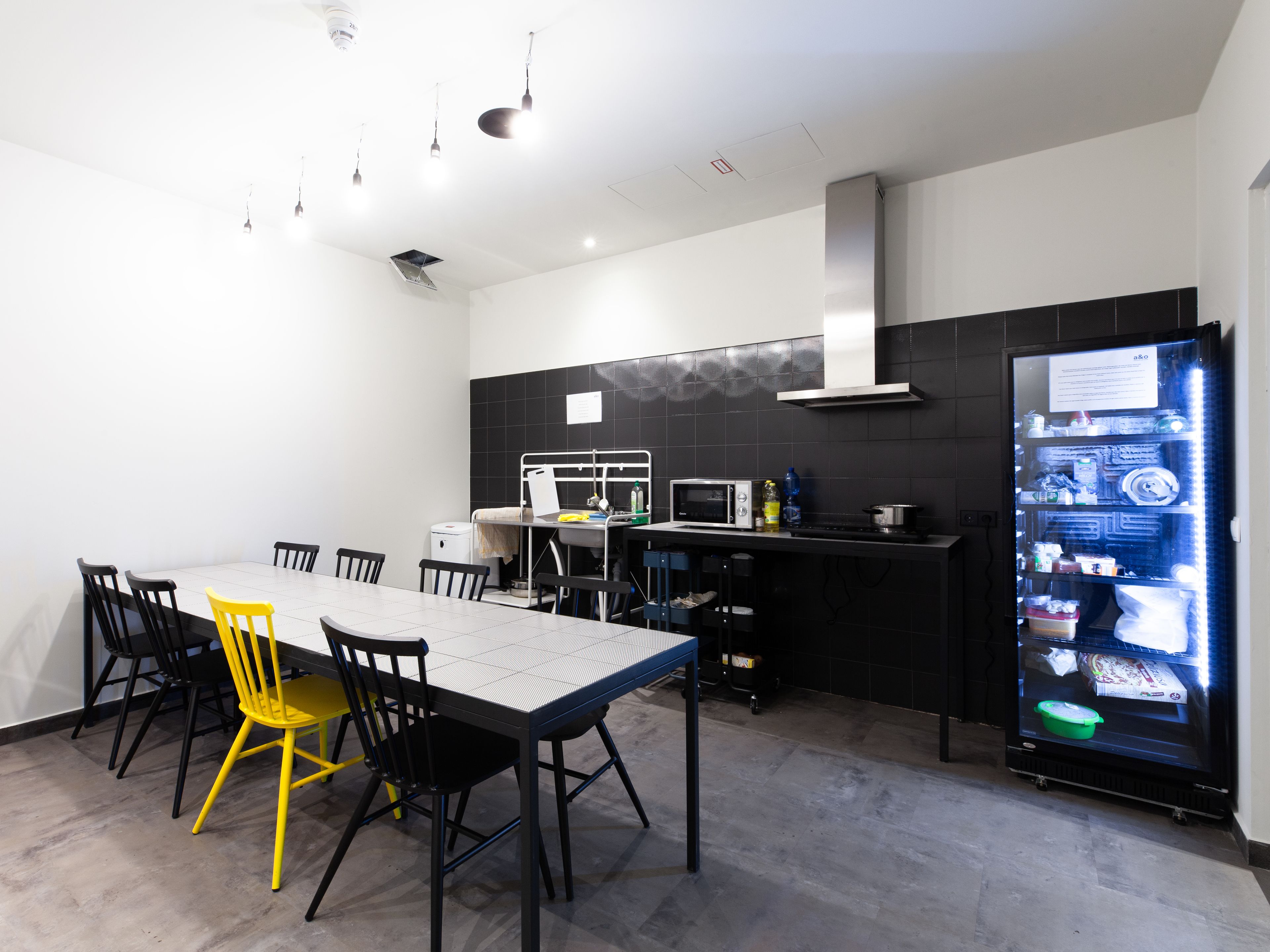 Una cocina moderna con comedor, equipada con microondas, estufa y refrigerador.