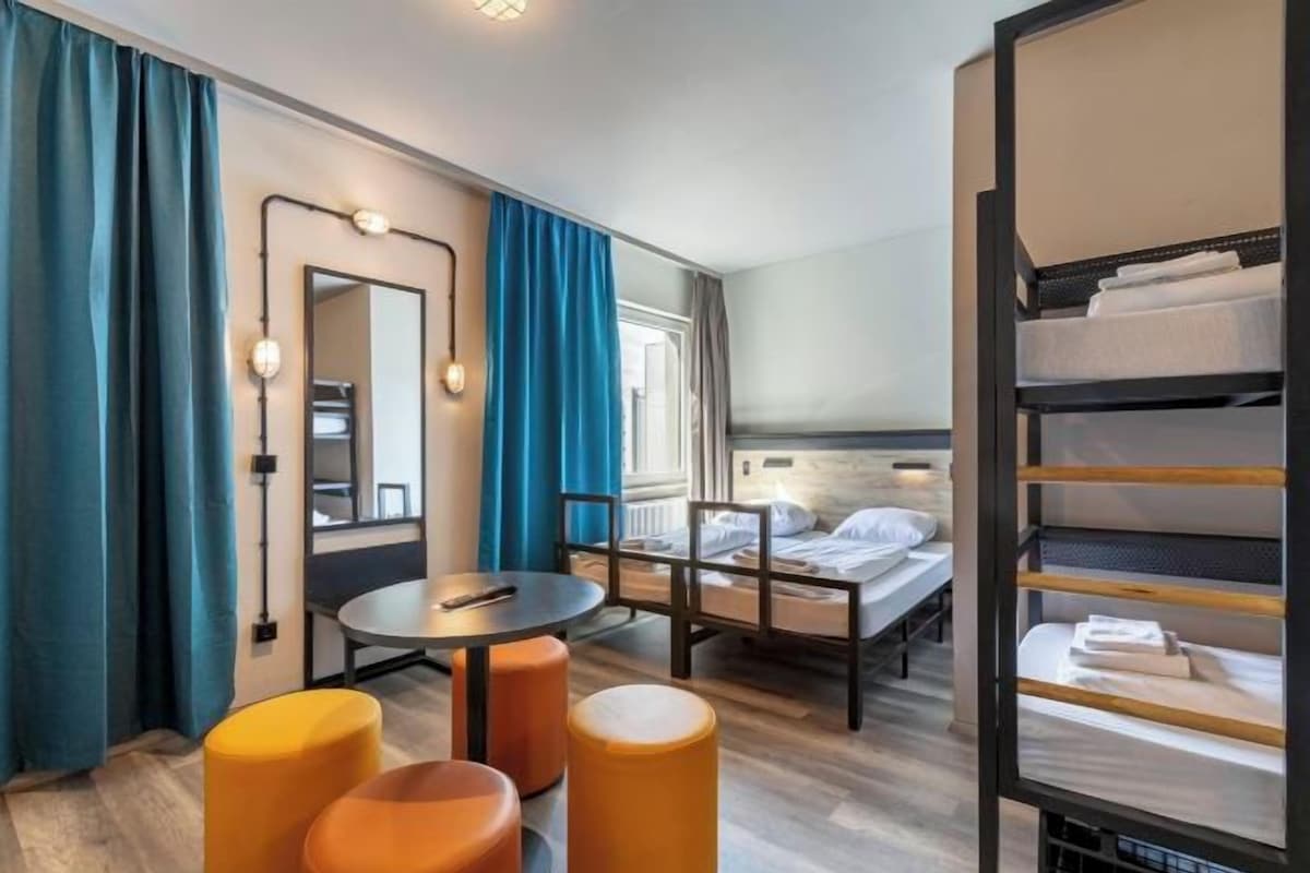 Ein Hotelzimmer mit Bett, Schreibtisch, Stuhl und Spiegel.