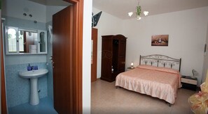 A bathroom with a sink and mirror, and a bedroom with a bed and wardrobe. - Residence Gli Ulivi (Leverano)