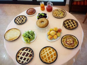 A table with various pies and fruits, including grapes and peaches, and two pitchers of juice. - Residence Gli Ulivi (Leverano)