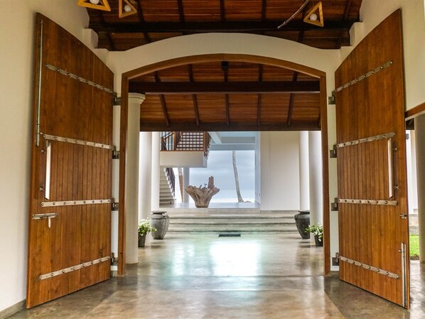 A grand entrance with large wooden doors and a stone sculpture in the center. - Villa Océane (Matara)