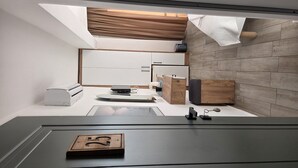 Una cocina moderna con horno empotrado, cafetera y un mueble de madera.