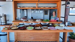 Una mesa de buffet con diversos alimentos y una máquina de café.