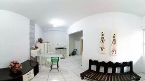 Un espacio habitable compacto con comedor, sofá y una pequeña mesa.