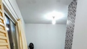 Una cocina compacta con piso de baldosas, una pequeña mesa de comedor, un refrigerador y un armario.