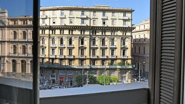 Un edificio de varios pisos con arquitectura clásica, que presenta balcones y ventanas arqueadas.