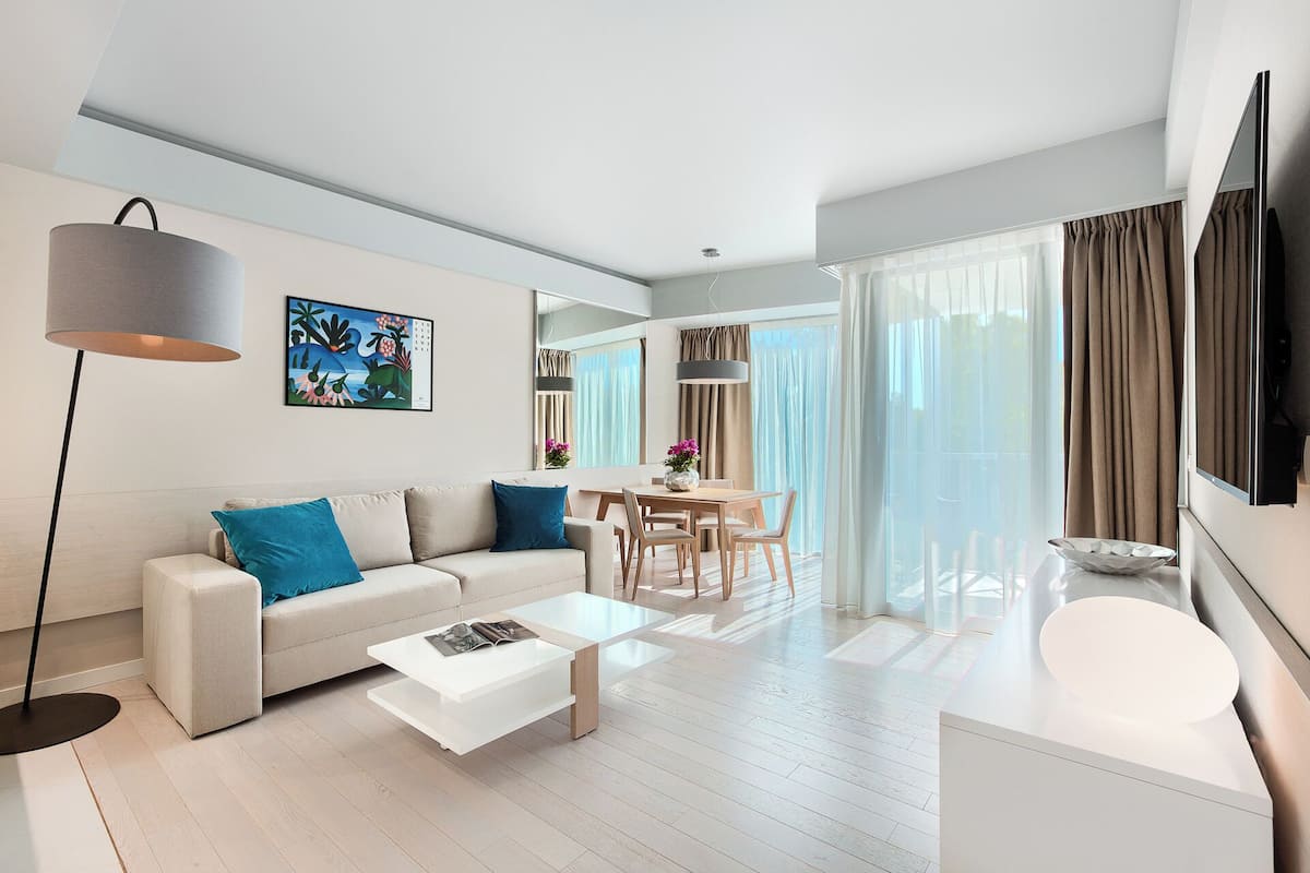Ein modernes Wohnzimmer mit Sofa, Couchtisch und Essbereich.