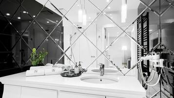 Un baño moderno con un espejo grande, dos lavamanos y una ducha.