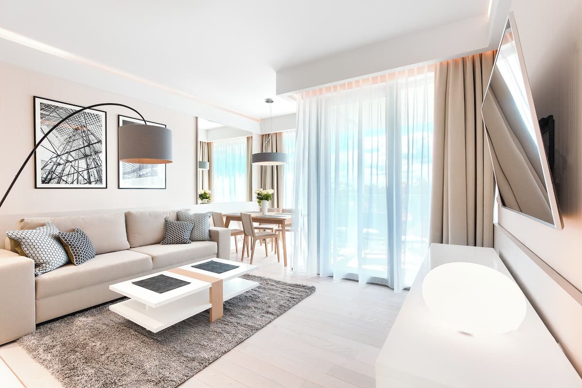 Ein modernes Wohnzimmer mit einer Couch, einem Couchtisch und einem Fernseher.