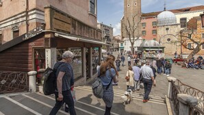 A busy street scene with pedestrians, a clock tower, and various buildings. - Ca' d'Oro Design by Wonderful Italy (Venice)