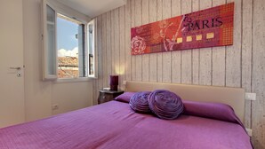 A bedroom with a bed, a window, a wall-mounted artwork, and a nightstand. - Ca' d'Oro Design by Wonderful Italy (Venice)