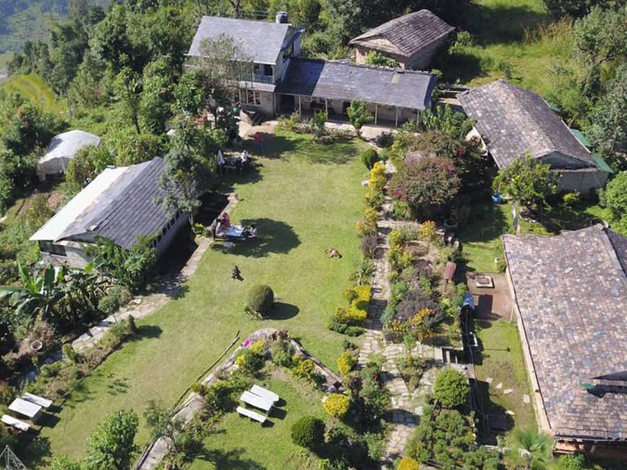 Zona residencial con varias casas, un césped central y vegetación circundante.