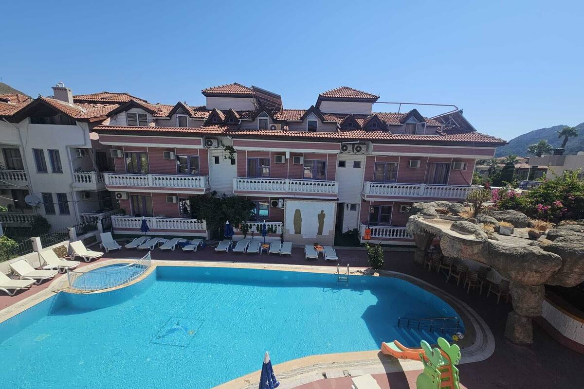 Un hôtel doté d’une piscine, de plusieurs balcons et offrant une vue sur le paysage environnant.