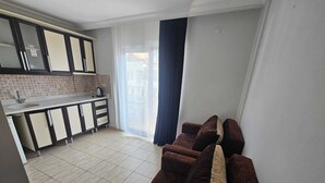Una cocina moderna con horno empotrado, un lavamanos y una ventana.