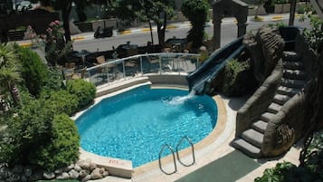 Una piscina al aire libre, sombrillas, tumbonas