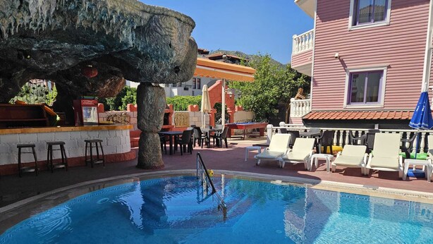 Piscina con sillas de descanso y zona de bar.