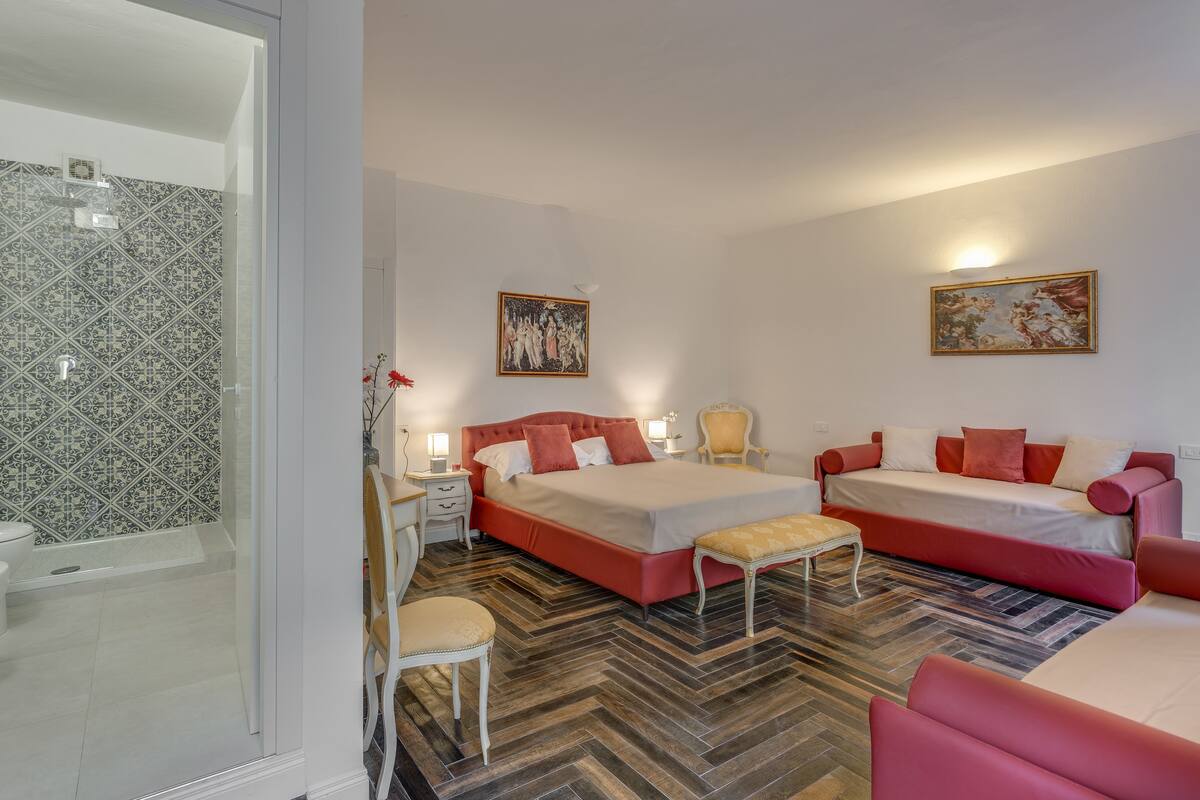 Une chambre à coucher comprenant un lit, un canapé, une chaise et une table de chevet.