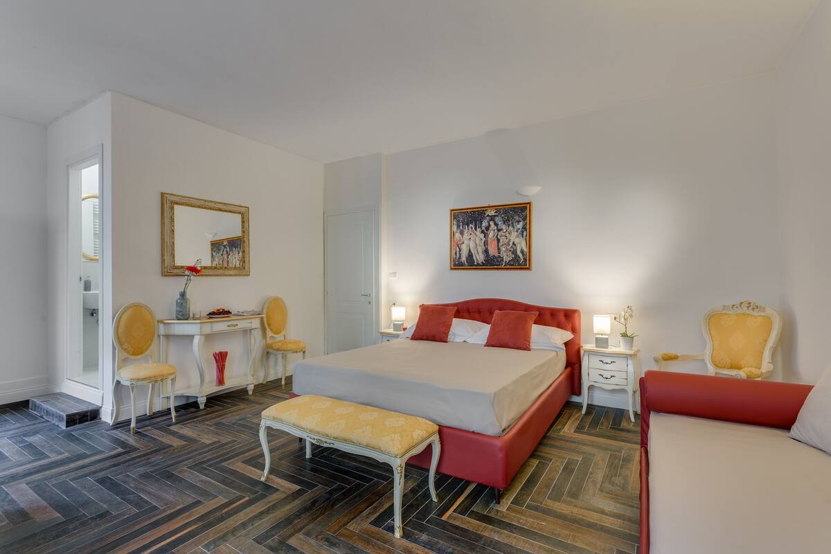 Une chambre d’hôtel moderne équipée d’un grand lit, d’un bureau, d’une chaise et d’un banc.