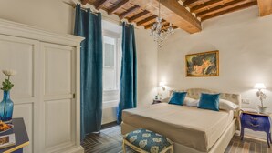 A bedroom with a bed, a nightstand, a chair, a painting, and a chandelier. - Residenza D'Epoca Sant Anna (Florence)