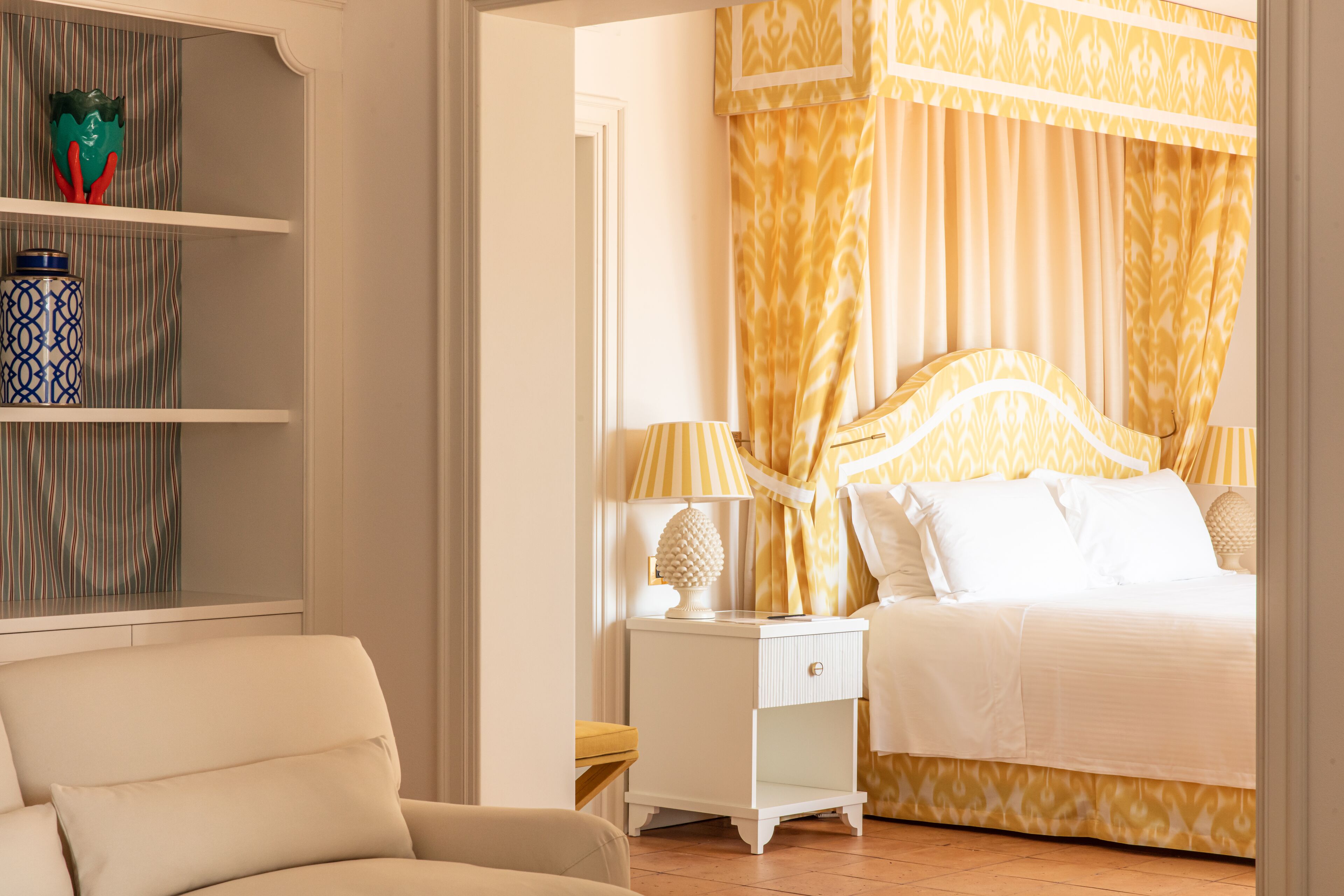 Un dormitorio con cama, mesitas de noche, una lámpara y una silla.