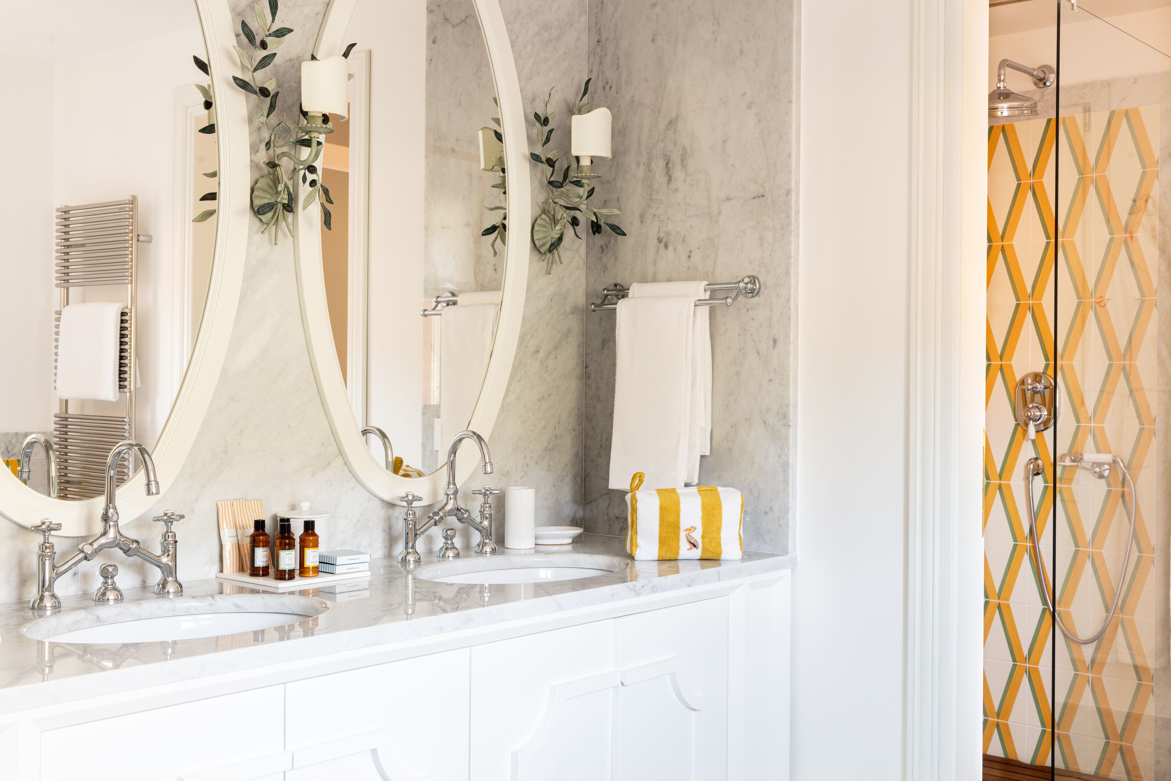 A bathroom with two sinks, a large mirror, and a shower area.