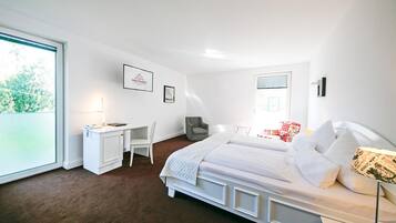 A bedroom with a bed, desk, chair, and a window with blinds.
