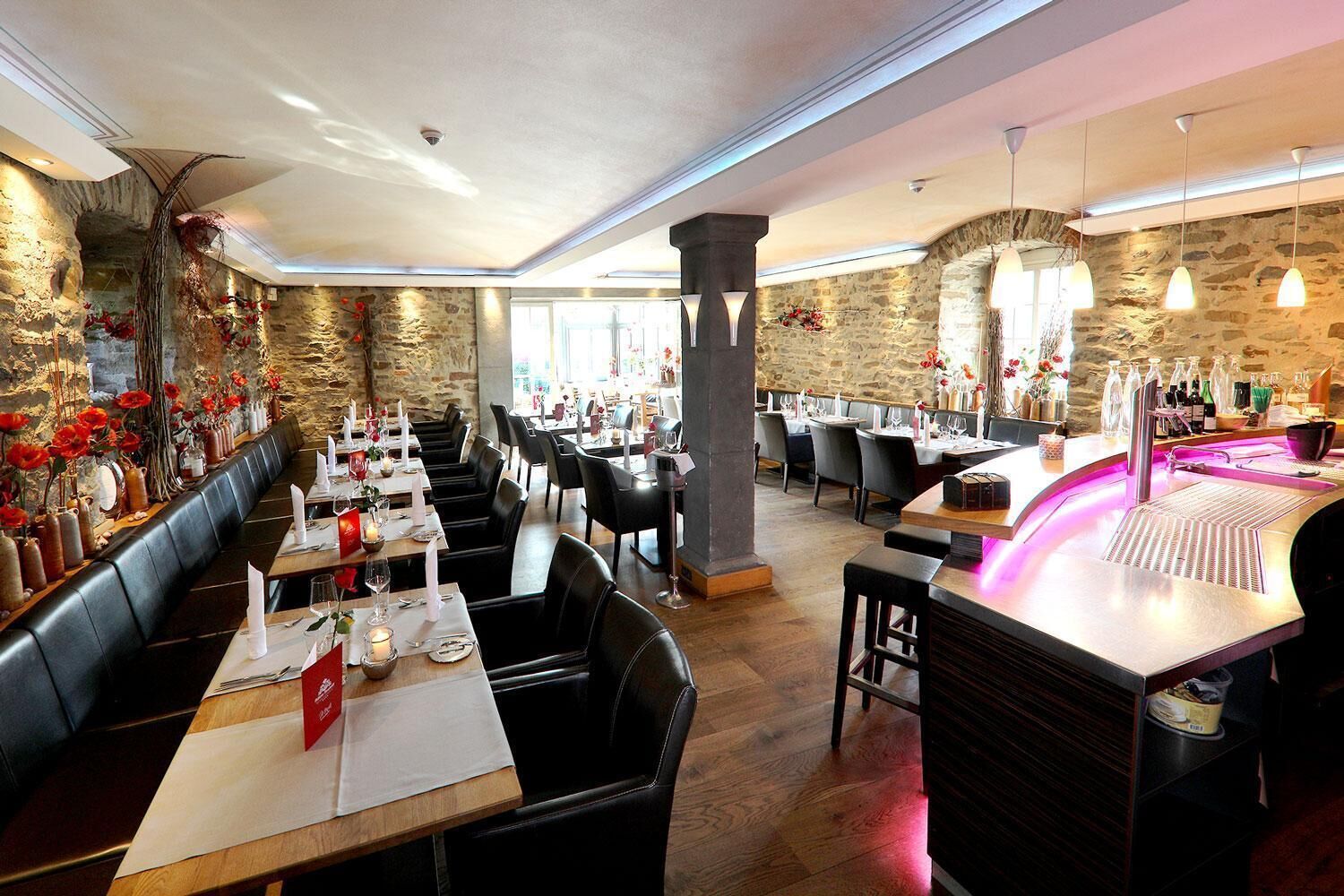 Ein Restaurant mit Stehwänden, Ledersitzen und einem Barbereich im modernen Stil.