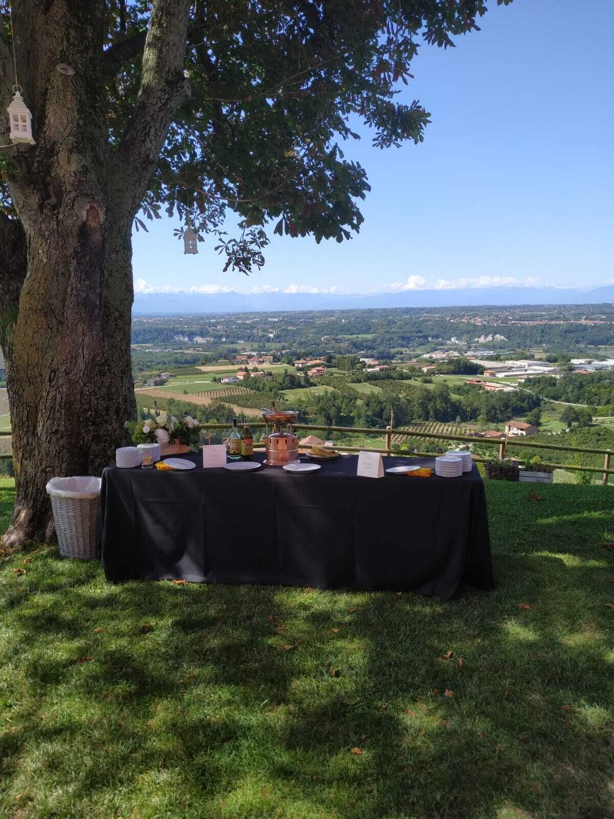 A table set outdoors with a view of a rural landscape.